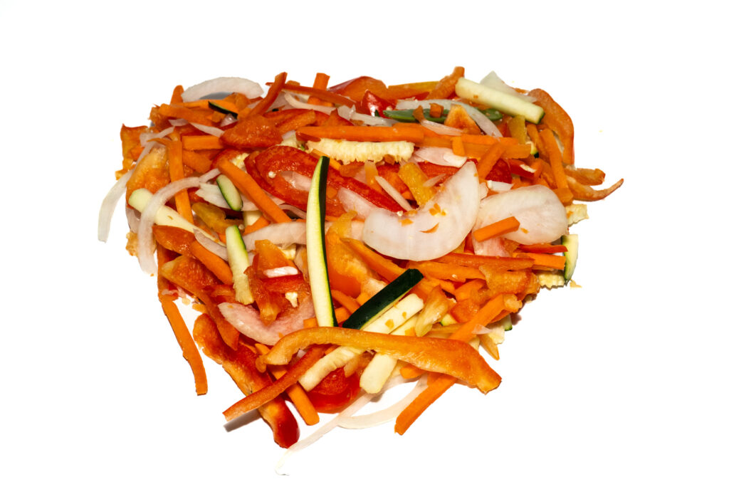 A mix of sliced vegetables including red bell pepper, onion, carrot and zucchini