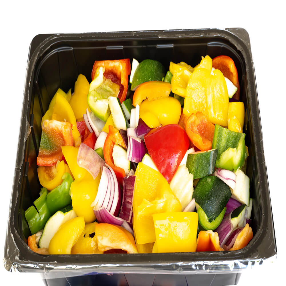 A mix of sliced vegetables including red and yellow bell peppers, red onions, and zucchini